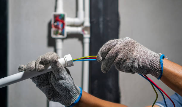 Electrician terminating color-coded feeder conductors on an industrial installation
